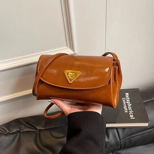 Vintage caramel brown leather pillow bag with gold triangular metal plaque and strap