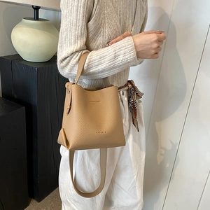 Chic litchi grain leather bucket bag in beige with top handle and crossbody strap