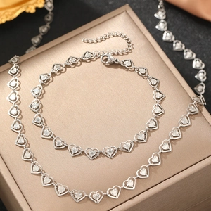 Détail macro du collier et du bracelet en argent avec des cœurs sculptés texturés