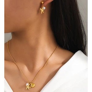Detail of model wearing starfish and shell jewelry set with pearls and snake chain