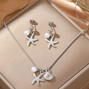 Stainless steel starfish shell jewelry set with necklace and earrings on satin fabric