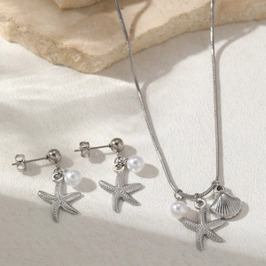 Close-up of starfish and seashell pendant set with pearls on a beach-style background