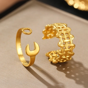 Detail of gold wrench shaped ring and woven texture band set with adjustable opening