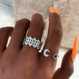 Close-up of silver minimalist mesh band and crescent open ring on hand with orange nails