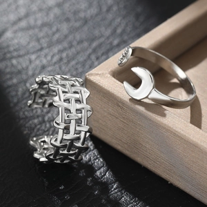 Detail of silver woven textured band and unique wrench shaped open ring set on leather