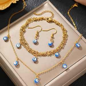 Golden evil eye jewelry set with blue enamel necklace, bracelet and earrings on display