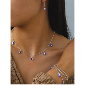 Detail shot of the Evil Eye necklace and bracelet set worn on a model in close-up view