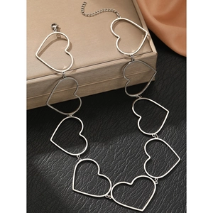 Detailed macro view of silver hollow heart-shaped links on a minimalist stainless steel chain