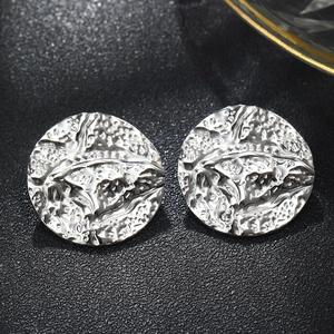 Macro shot of silver round stud earrings featuring unique hammered water ripple texture
