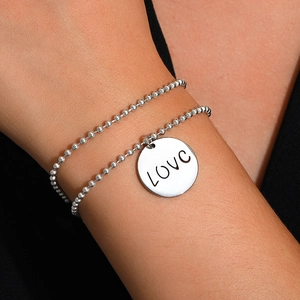Makroaufnahme Silberperlenarmband mit poliertem runden Anhänger und Love Gravur