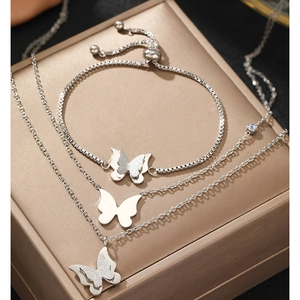 Detail of silver double-layered butterfly necklace and adjustable bracelet set on jewelry box