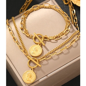 Detail of vintage gold coin necklace and bracelet set with T-bar closure and coin charms