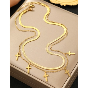 Détail d'un collier double épaisseur à pendentifs croix dorés sur boîte à bijoux