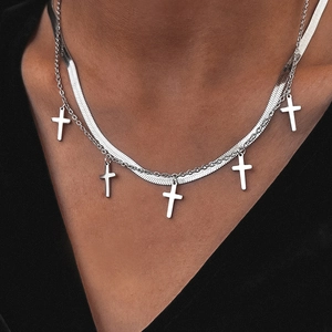 Détail d'un collier double épaisseur argenté avec chaîne serpent et croix au cou