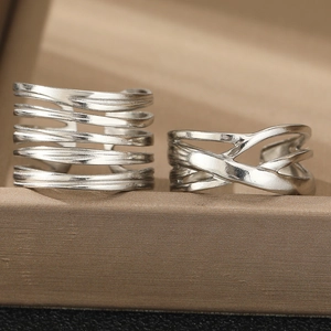 Macro shot of silver multilayer cross open ring set on a premium jewelry box