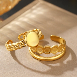 Detail of vintage double-layered gold stainless steel rings on a champagne base