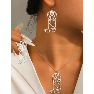 Detail view of hollow cowboy boot earrings and necklace set on a model