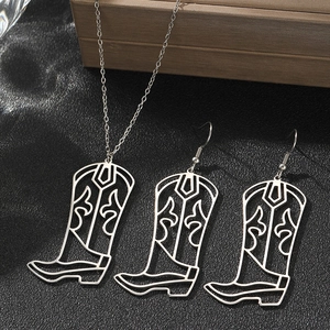 Detail of western star cowboy boot pendant necklace and earrings on black leather