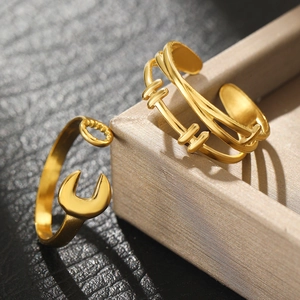 Detail of two gold spinning rings with wrench gear and multi-layer textured designs