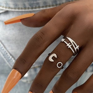 Macro shot of silver layered winding rings and geometric open rings on a hand