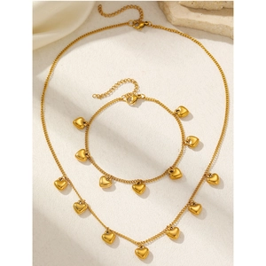 Detailoverzicht van de gouden roestvrijstalen set ketting en armband met hartbedels