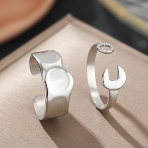 Macro shot of silver wrench and lava texture stainless steel rings on display