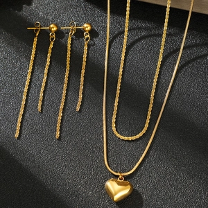 Parure collier double rang pendentif coeur et boucles d'oreilles pompon sur fond noir