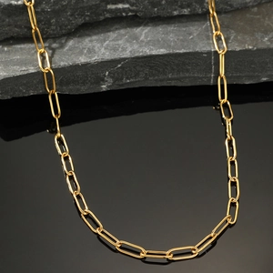 Macro shot of gold paperclip chain necklace showcasing polished metallic link textures
