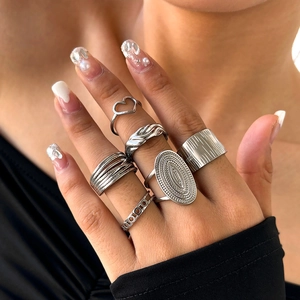 Set of 6 silver stackable adjustable rings with textured and heart patterns on female hand