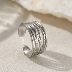 Detailed view of silver multi-layer crisscross ring with textured and polished bands