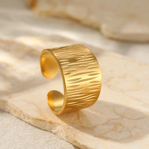 Macro detail of 18K gold plated wide band ring featuring a unique bark texture design