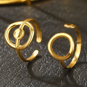 Minimalist gold hollow rings with interlocking geometric lines on black leather background