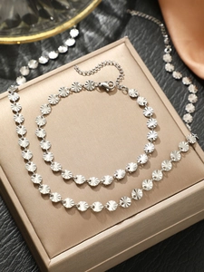 Detail showing silver sunburst disc necklace with lobster clasp and adjustable chain