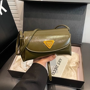 Green leather shoulder bag with gold triangular logo shown in luxury gift box packaging