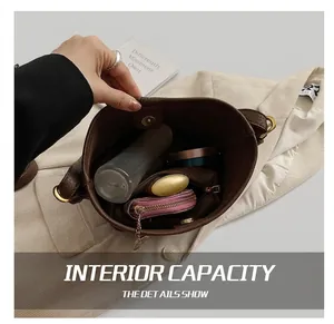 Vue de dessus de l'intérieur du sac seau en cuir marron montrant sa capacité de rangement