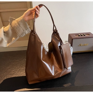 Detail view of deep brown hobo bag with a matching small zipper pouch and metal rings