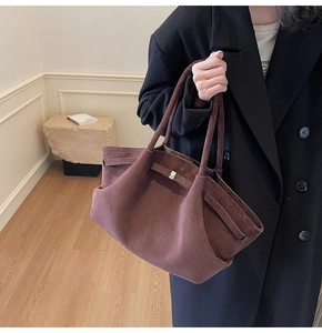 Gros plan sur le cabas en daim marron avec boucles latérales et texture cuir dépoli fine