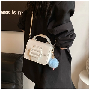 Mini borsa quadrata bianca in pelle opaca con ciondolo pompon blu su modella