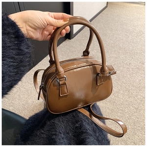 Detailed shot of coffee brown mini bowling bag with glossy finish and silver hardware
