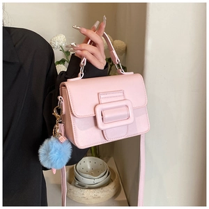 Dettaglio mini borsa a tracolla rosa con fibbia quadrata e ciondolo di peluche blu