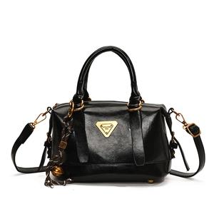 Glossy black textured leather handbag with gold logo and adjustable shoulder strap