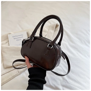 Detailed view of deep coffee handheld bowling bag with adjustable strap and silver hardware