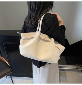 Détail latéral d'un grand sac cabas en daim beige crème porté par un mannequin