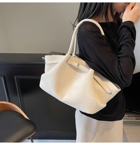 Détail du grand sac cabas en daim blanc mat avec poignées cylindriques et boucle décor