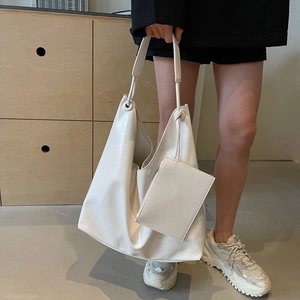 Minimalist white hobo tote bag with a small pouch on a stylish modern background