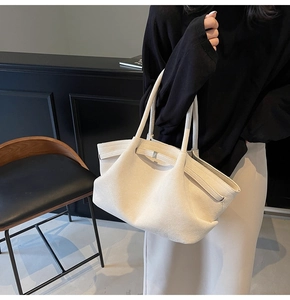 Détail du sac cabas en daim crème montrant sa texture mate douce et sa structure seau