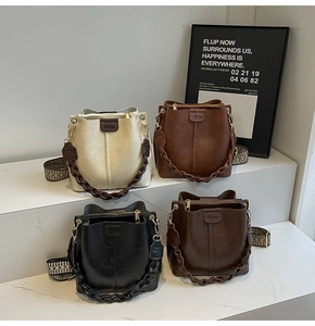 Detail of four retro bucket bags in white, caramel, coffee and black with wide straps
