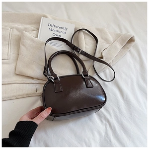 Detail of dark brown bowling bag with silver hardware and adjustable shoulder strap