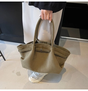 Gros plan du sac cabas en daim vert olive avec texture mate et détail de boucle métallique