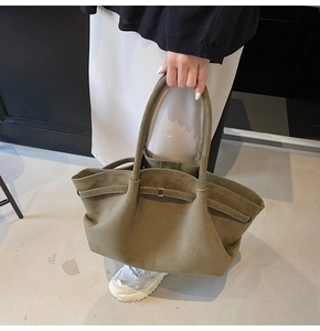 Détail du sac fourre-tout en daim vert olive avec texture souple et fermoir métallique